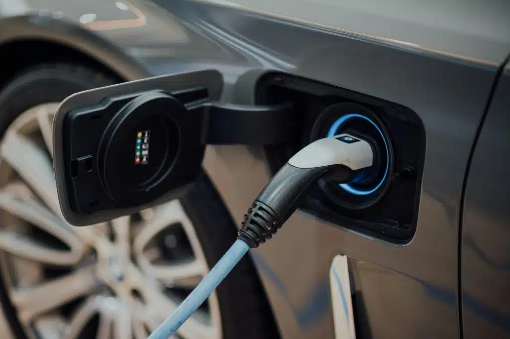 Voiture électrique en train de charger avec un cable d'une borne de recharge privée propre.